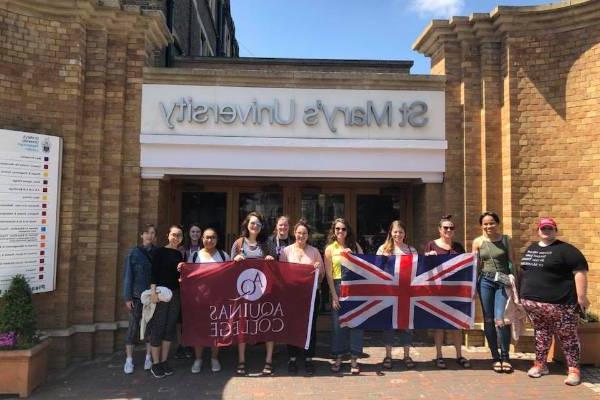 学生们举着十大赌博登录官网旗和英国国旗站在圣. 玛丽的大学